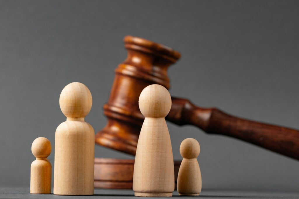 Wooden toy family and judge mallet. Family divorce concept